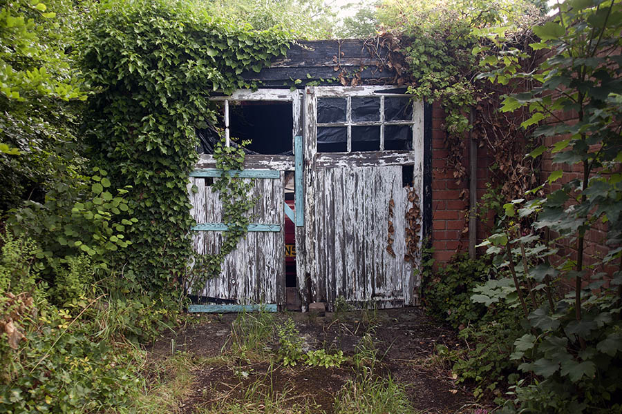 Photo 06601: Decayed, panelled, white garage door