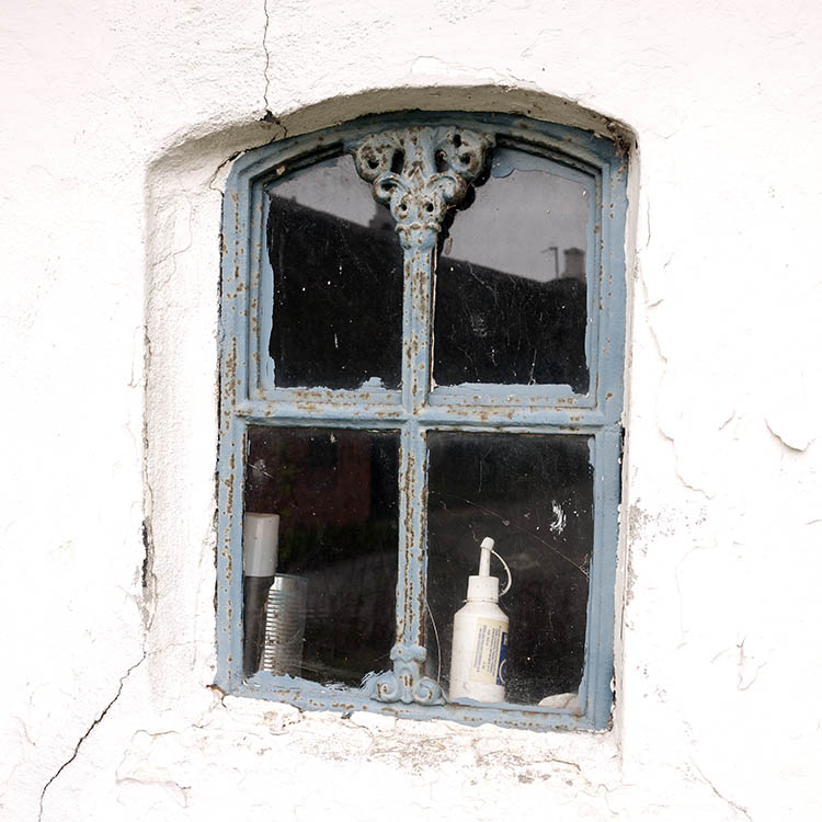Photo 08321: Worn, light blue metal cast iron window
