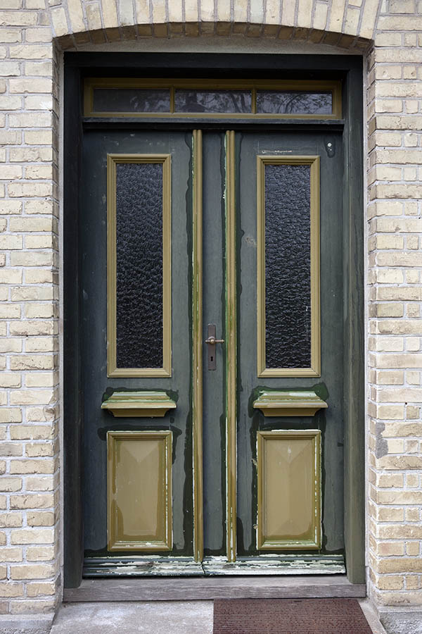Photo 11159: Panelled, brown and green double door under repair. Top window and door lights.