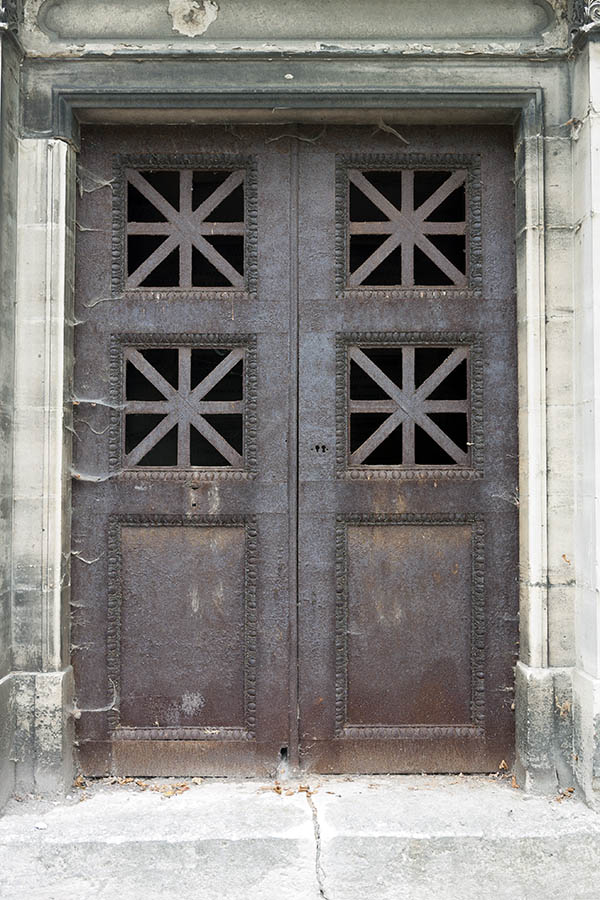 Photo 15600: Worn, rusty, brown metal double door with barred door lights