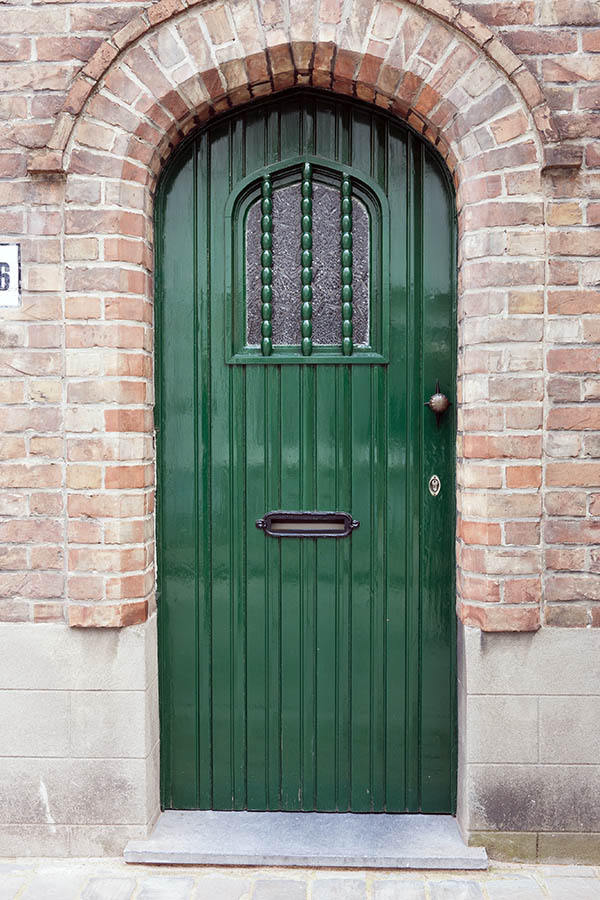 Photo 15912: Formed, green door made of planks with a formed, barred door light