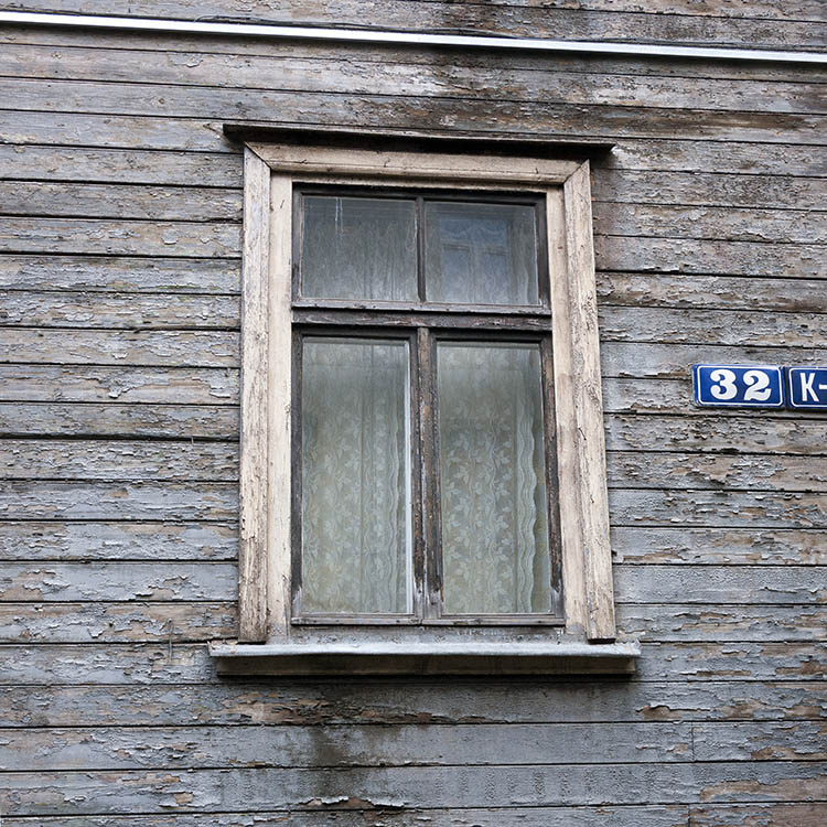 Photo 19002: Worn, brown T-post window with four panes in an unpainted, outer frame