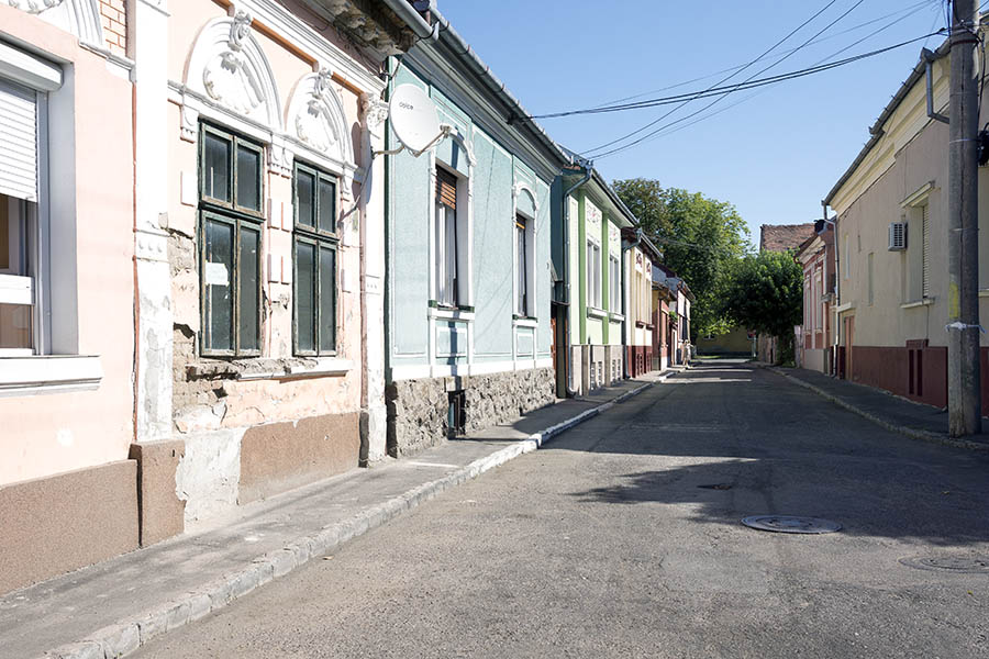 Photo 25698: Street with facades of Romanian family houses in pink, grey, green and red