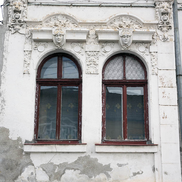 Photo 25780: Facade with two formed, red windows in a exquisitely plastered, white wall