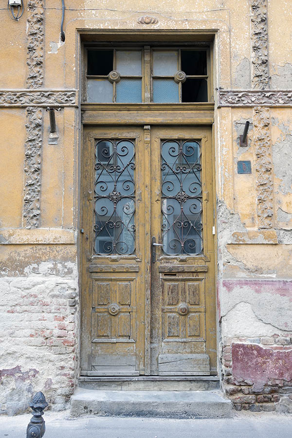 Photo 25819: Decayed, panelled, carved, yellow double door with latticed door lights and broken top window