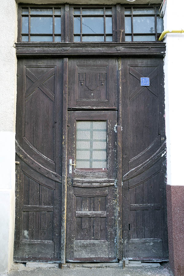 Photo 25838: Worn, panelled, carved, formed, brown gate with minor door and top windows