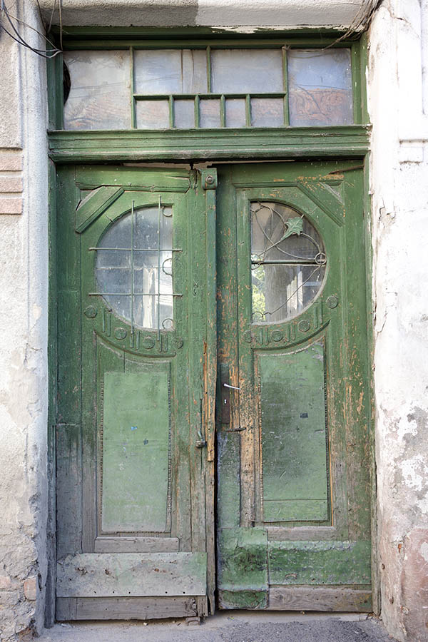 Photo 25872: Decayed, formed, carved, panelled, green and unpainted double door with latticed door lights and top