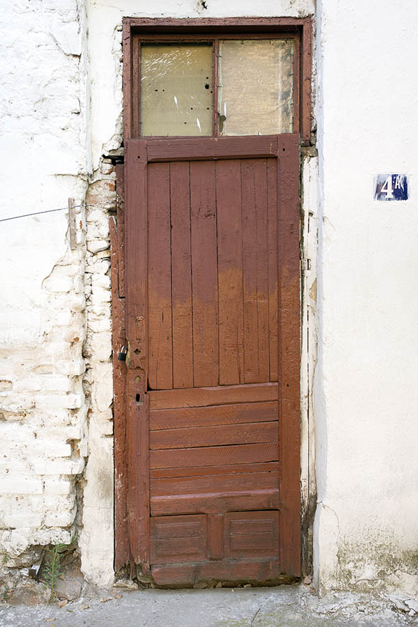 Photo 26337: Worn, lopsided, panelled, brown door with top window