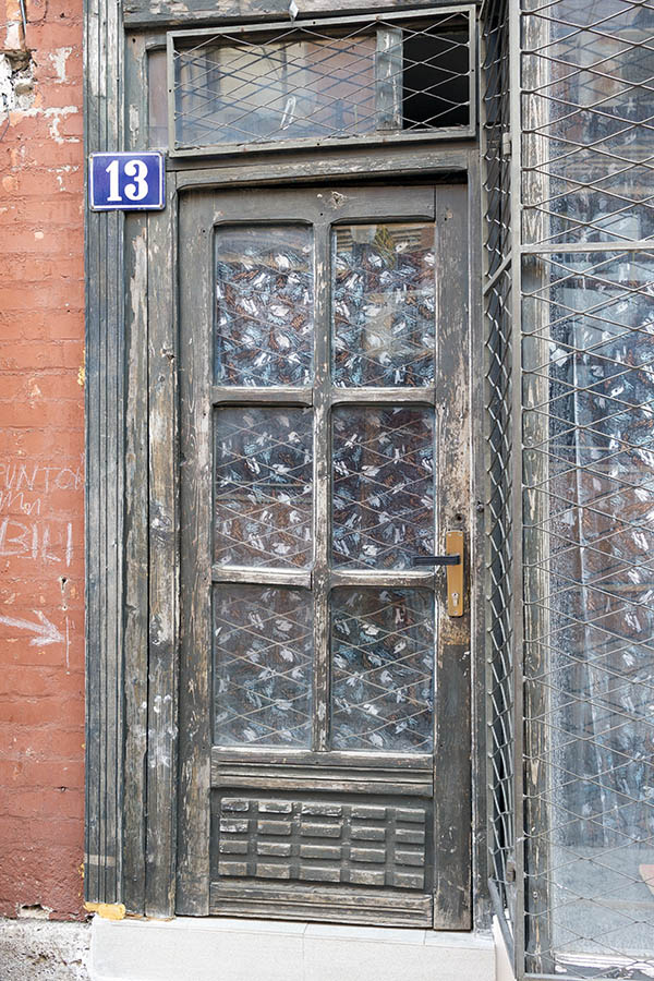 Photo 26352: Worn, panelled, brown and unpainted door with latticed door lights, top window, and shop window