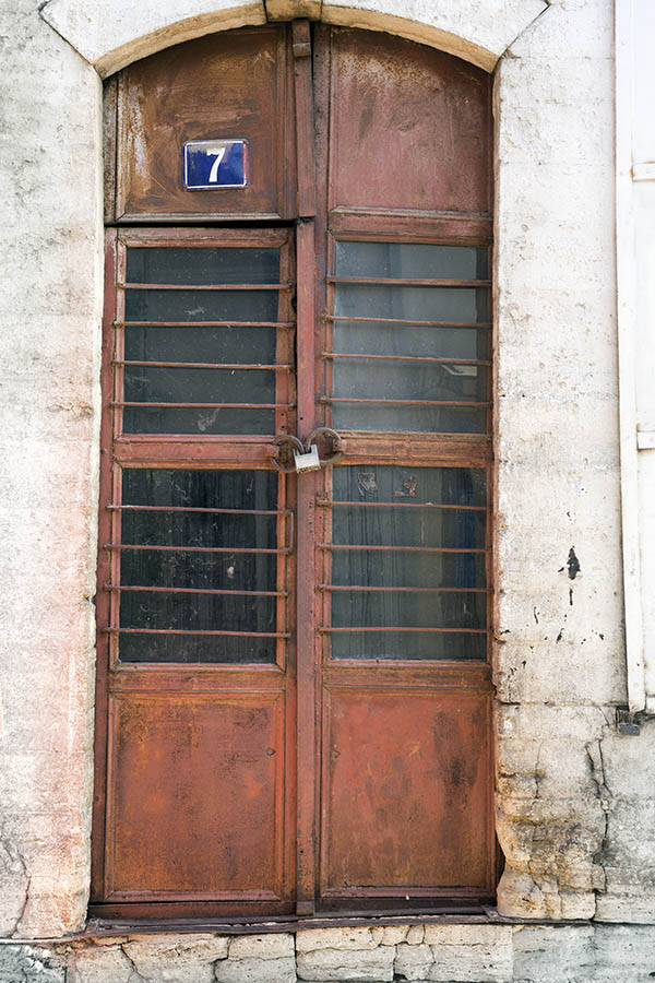 Photo 26372: Lopsided, formed, panelled, rusty, brown metal double door with barred door lights