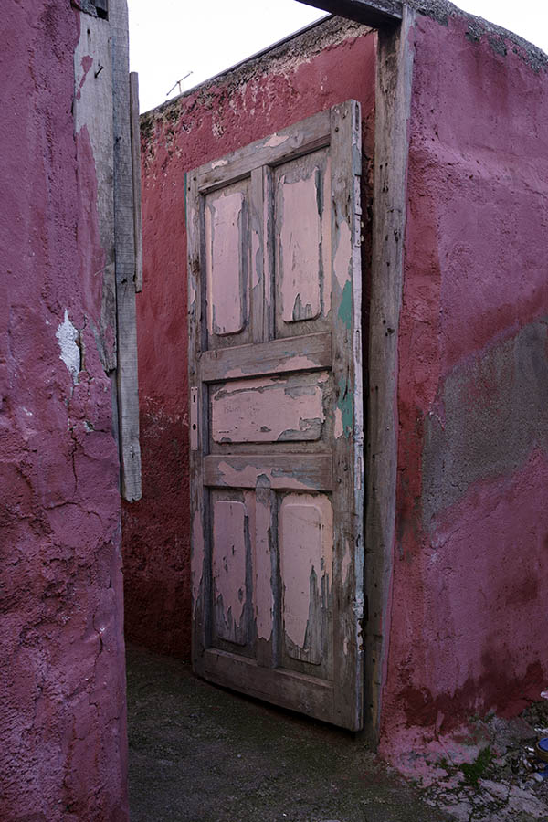 Photo 26459: Decayed, pink, panelled door leading to a yard
