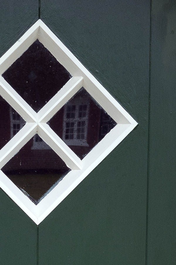 Photo 09756: Formed, green and white half-door made of planks with a diamond-shaped door light