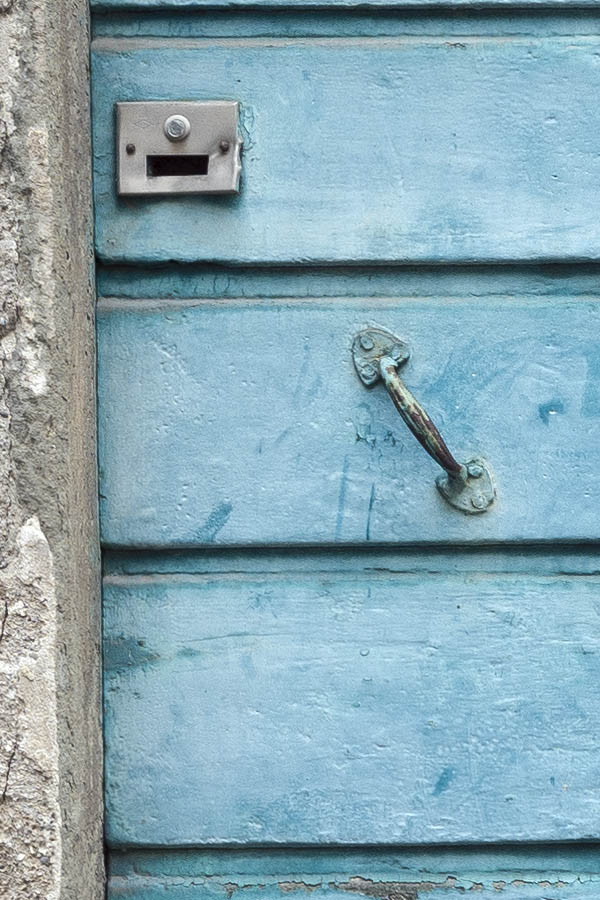 Photo 15182: Decayed, light blue double door made of planks with barred, white top window