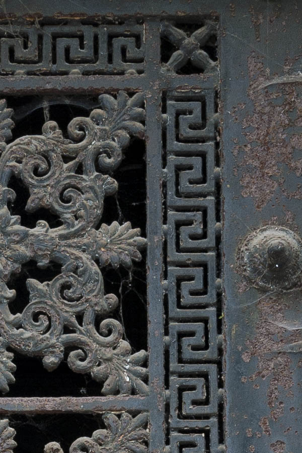 Photo 15606: Decayed, grey and rusty cast iron door with a-la-greque pattern, etc.