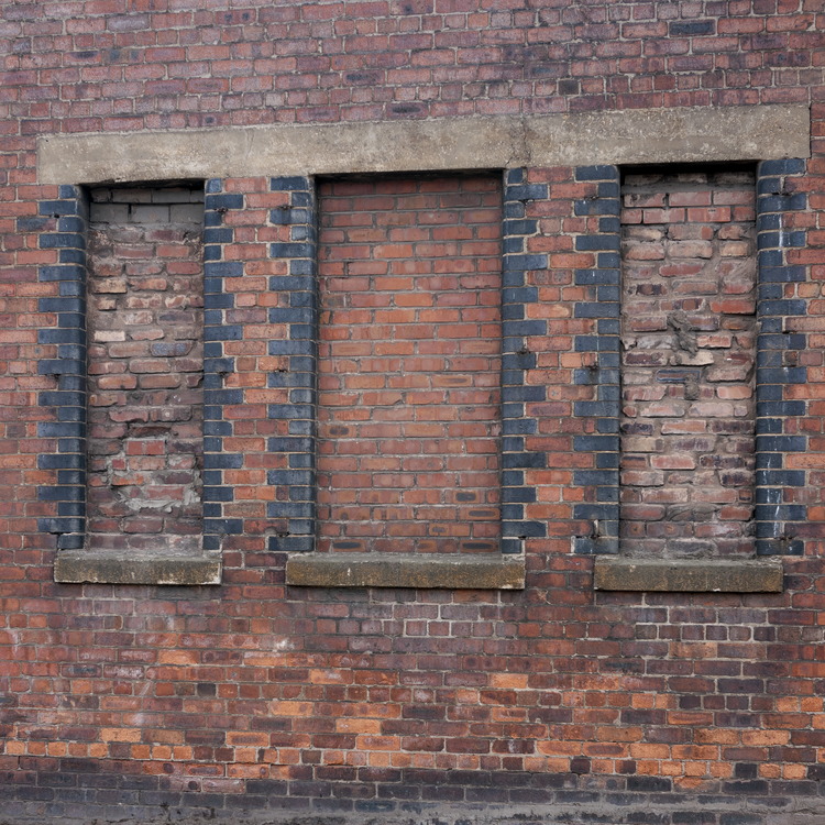 Photo 11614: Worn, red and black brick wall with three indentations