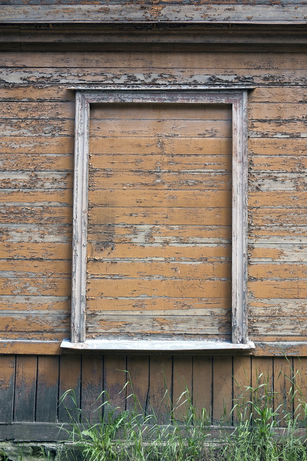 Photo 19781: Decayed, light brown wall of planks with empty, white window frame