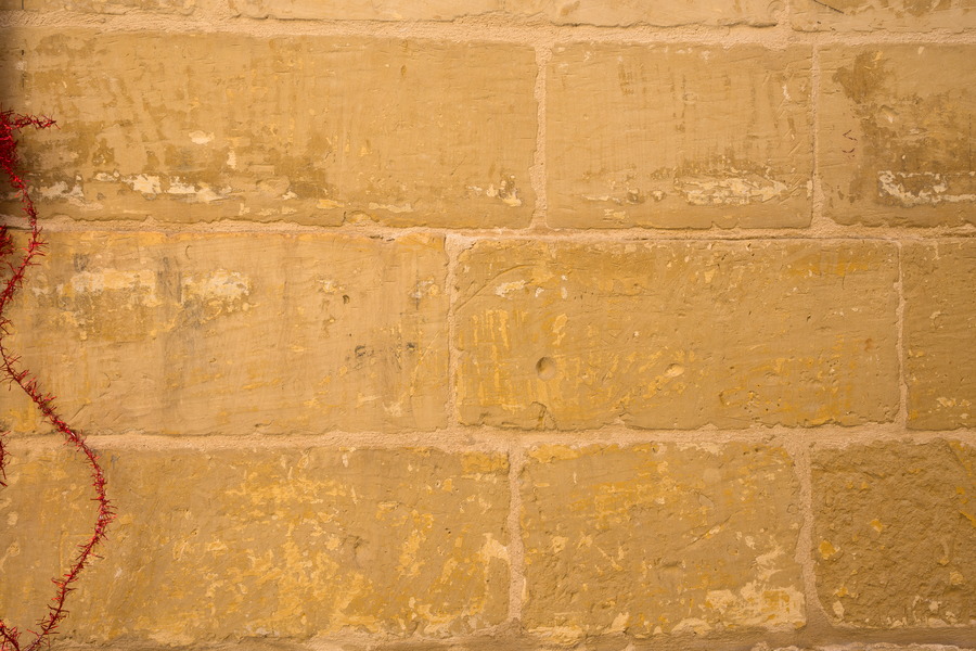 Photo 24142: Worn, yellow sandstone wall.