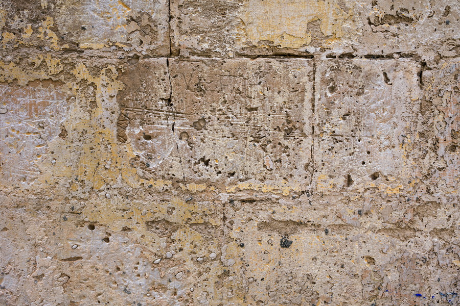 Photo 24277: Worn, grey and yellow sandstone wall.