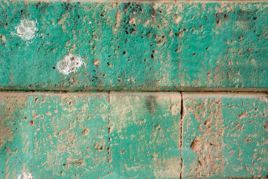 Photo 24348: Worn, yellow and green sandstone wall