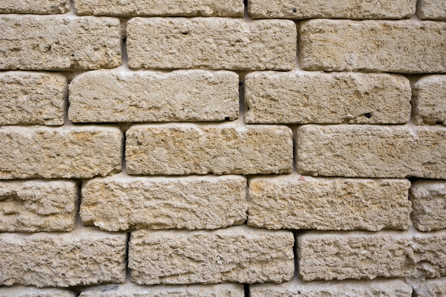 Photo 24435: Worn, yellow sandstone wall.