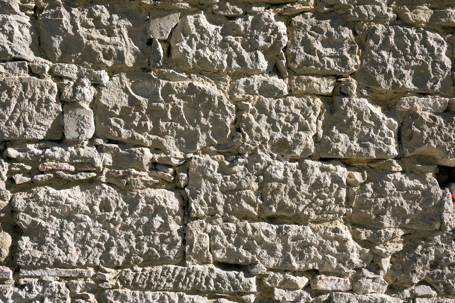 Photo 24691: Worn, light yellow sandstone wall