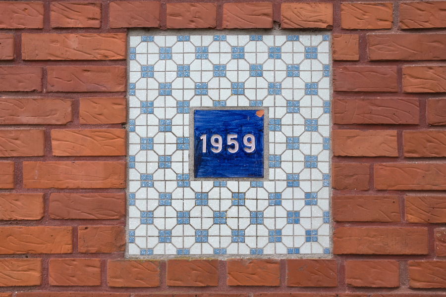 Photo 25167: Red brick wall with tiles in indentation and text 