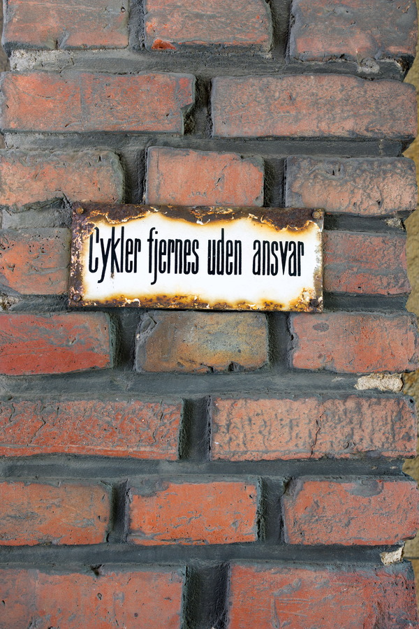 Photo 25222: Worn, red brick wall with rusty sign 