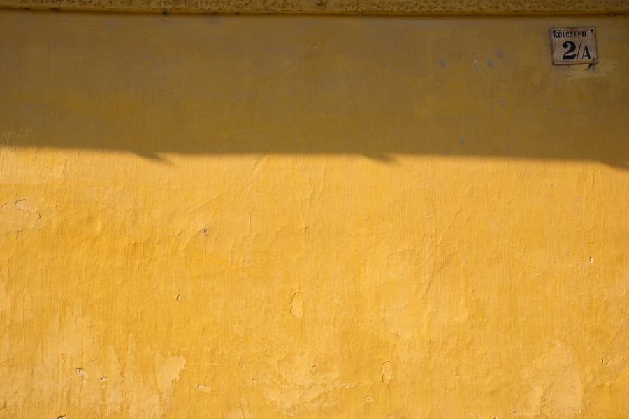 Photo 25979: Yellow, plastered wall with sign 