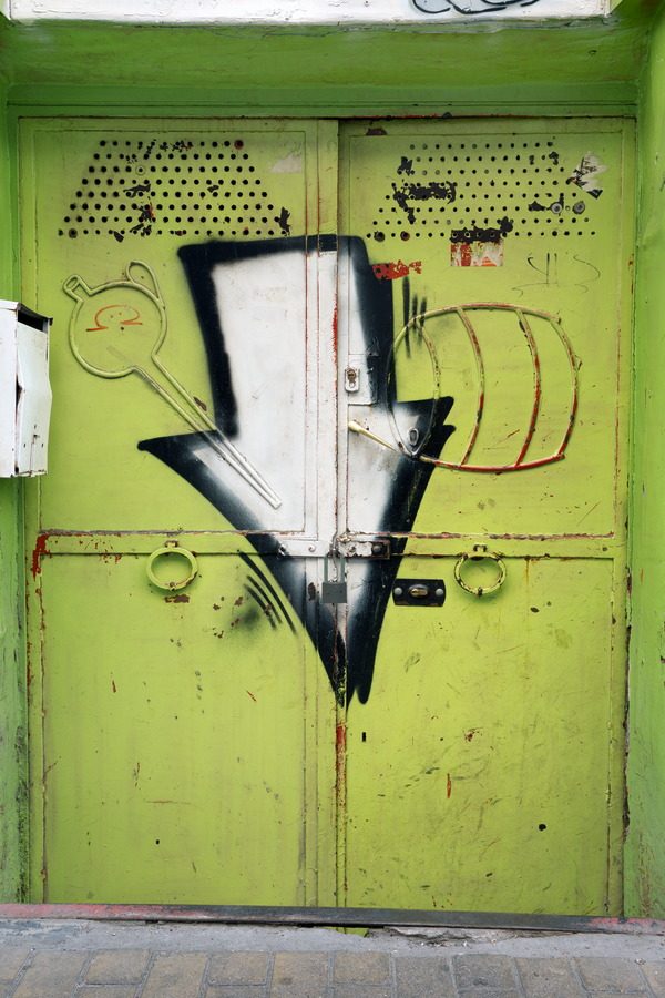 Photo 26062: Worn, light green metal double door with grafitti arrow