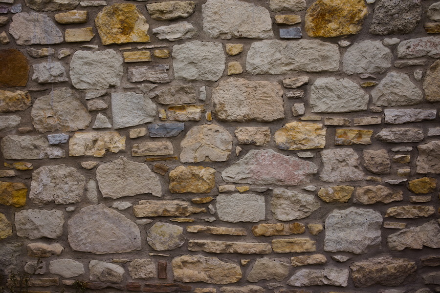 Photo 27431: Stone wall with yellow and grey stones of various sizes. Well maintained.