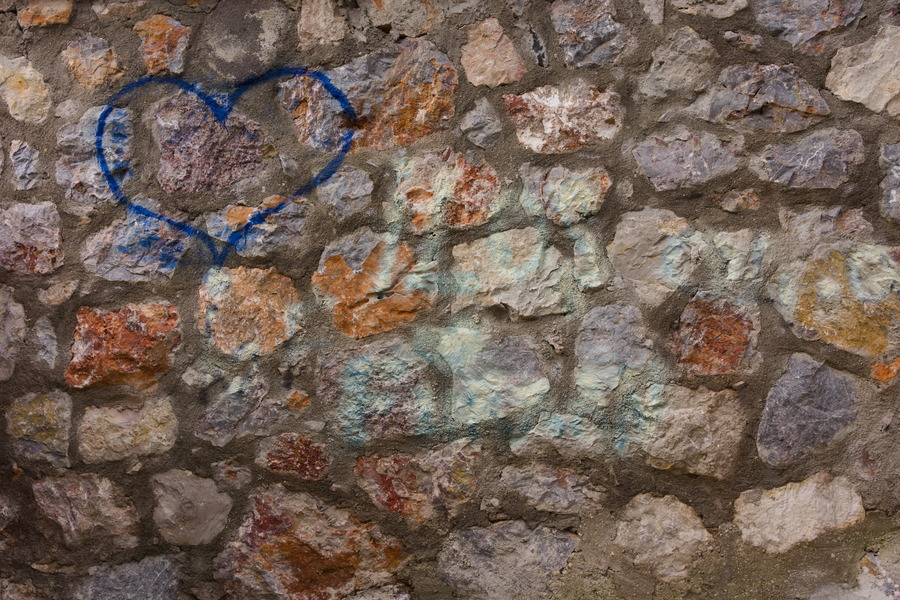 Photo 27433: Stone wall with grey, blue, and red stones and grafitti