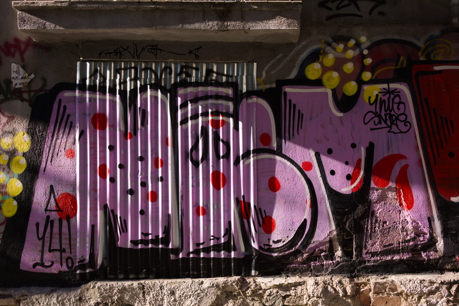 Photo 27478: Security shutter with grafitti: Four letters in black, white, red and violet