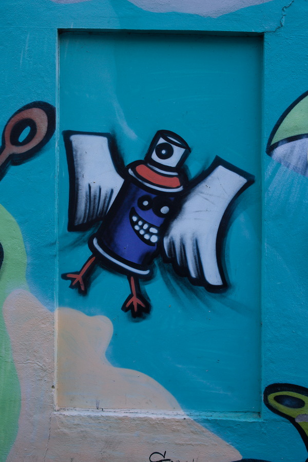 Photo 27488: Plastered wall with indentation and grafitti: Flying spray paint in blue, red, green, black and white