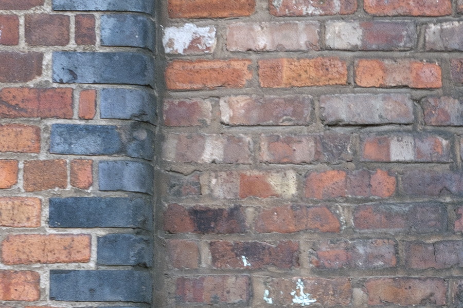 Photo 11610: Worn, red and black brick wall with indentation