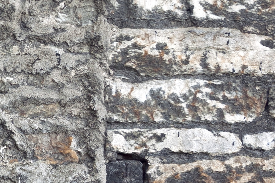 Photo 19850: Worn, grey and white brick wall with remains of a window