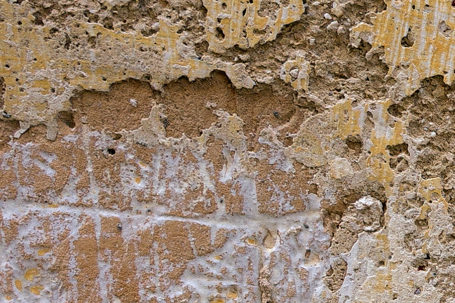 Photo 24277: Worn, grey and yellow sandstone wall.