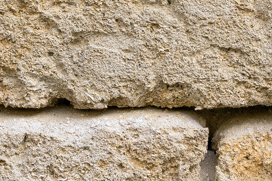 Photo 24435: Worn, yellow sandstone wall.