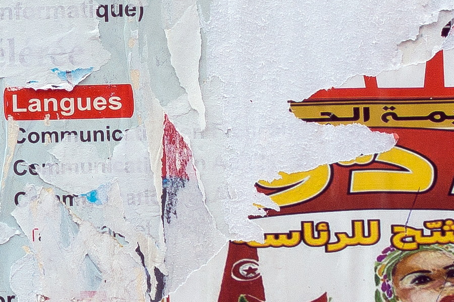 Photo 24542: Wall with worn posters in white, blue, red and yellow