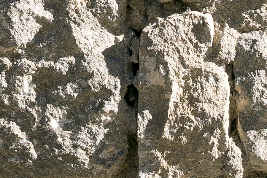 Photo 24691: Worn, light yellow sandstone wall