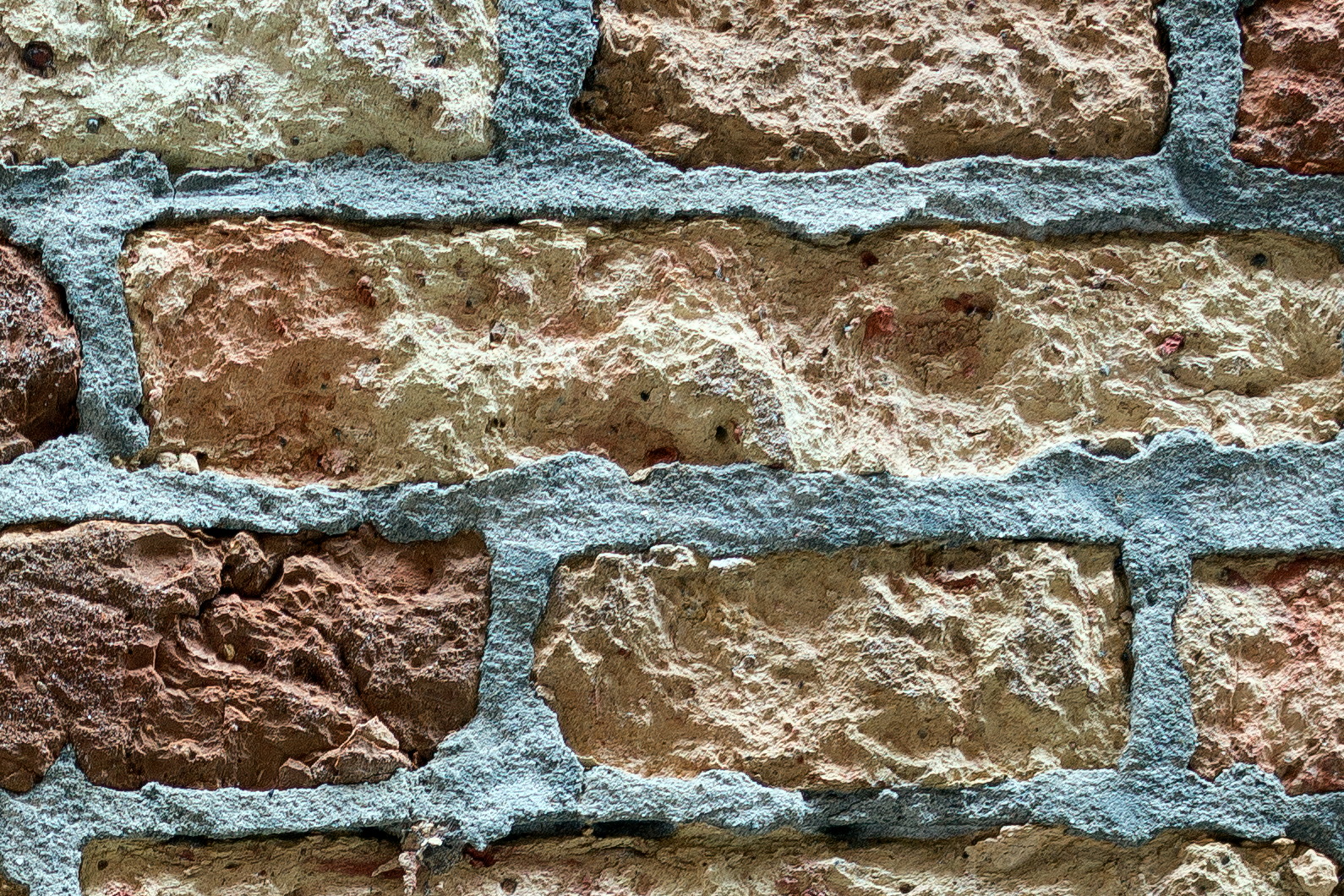 Photo 24852: Worn brick wall in yellow and red with grey or blue mortar