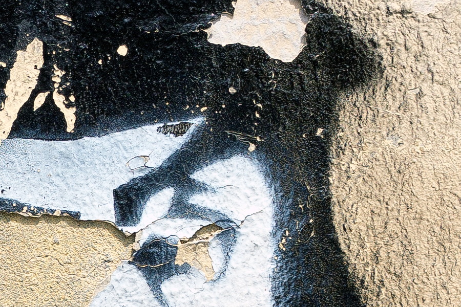 Photo 26168: Decayed, plastered, light yellow wall with grafitti: A long-haired officer?