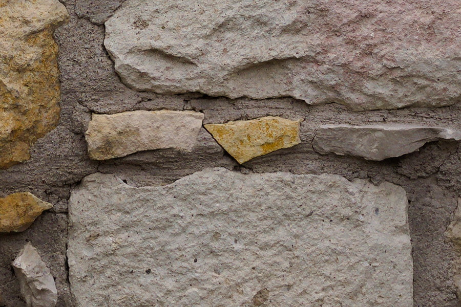 Photo 27431: Stone wall with yellow and grey stones of various sizes. Well maintained.